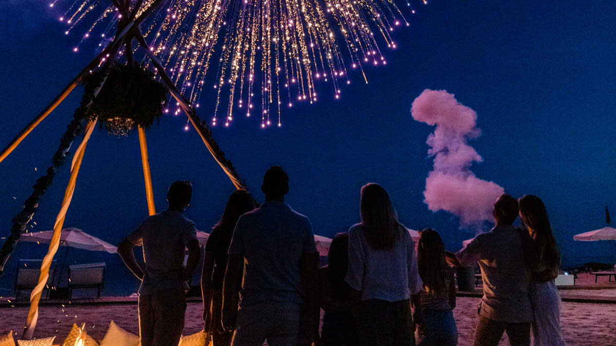 Family against a night sky watching fireworks