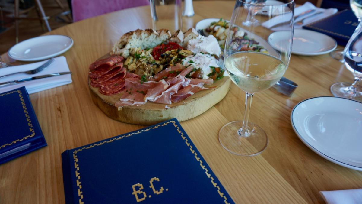 Charcuterie board and wine on a table at Bar Corallini