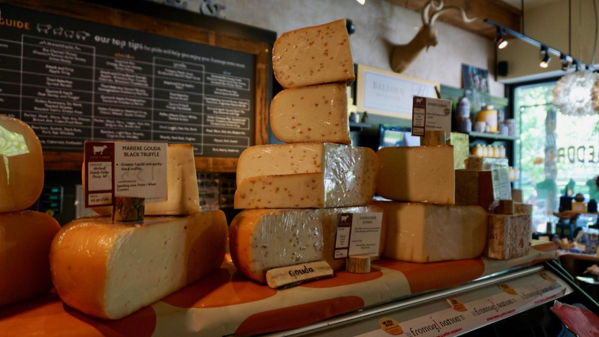 Different varieties of cheese stacked on the counter at Fromagination