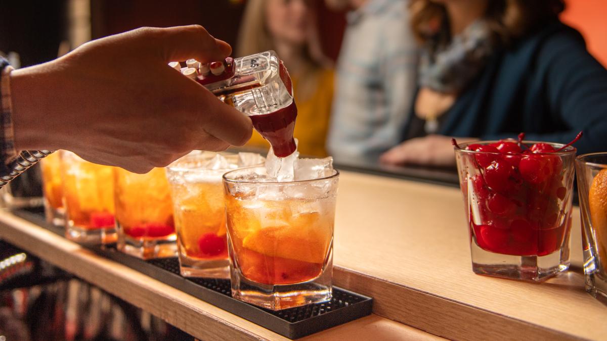 A bartender makes a row of Old Fashioneds at Tornado Room