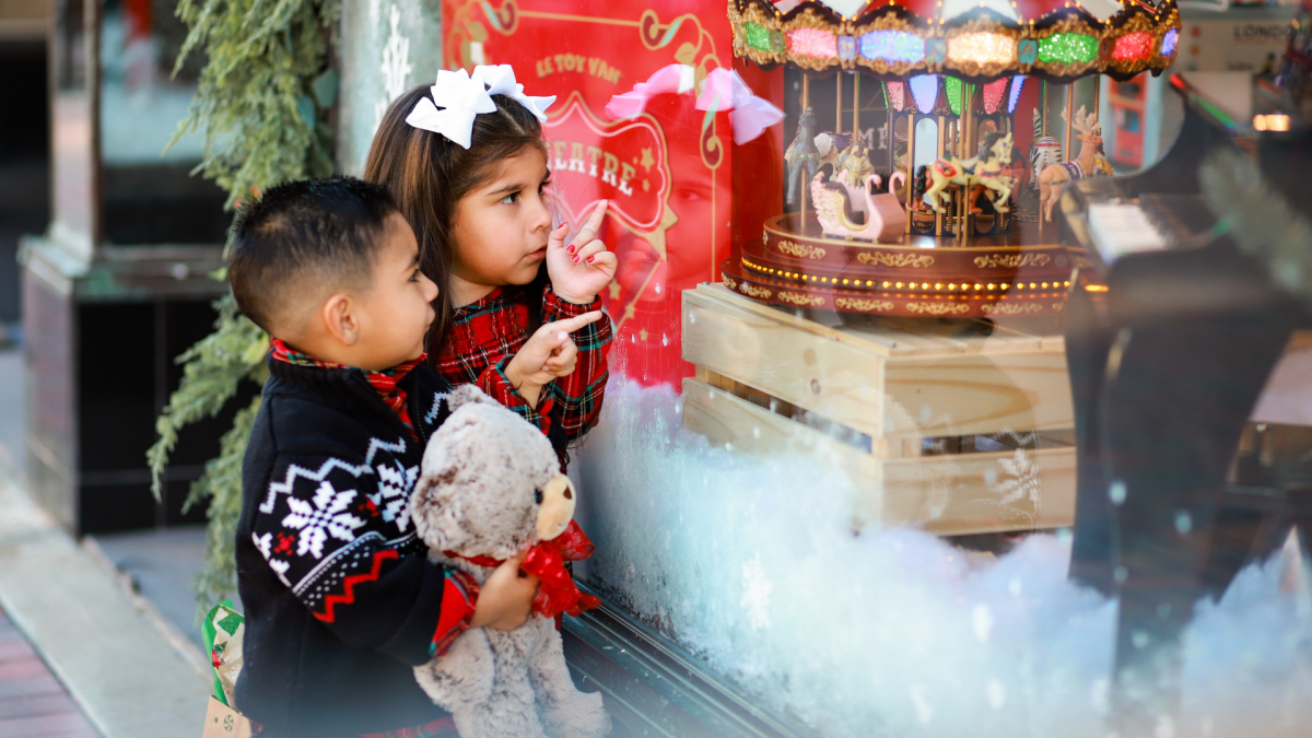 Young children looking in a window display at Christmas decorations