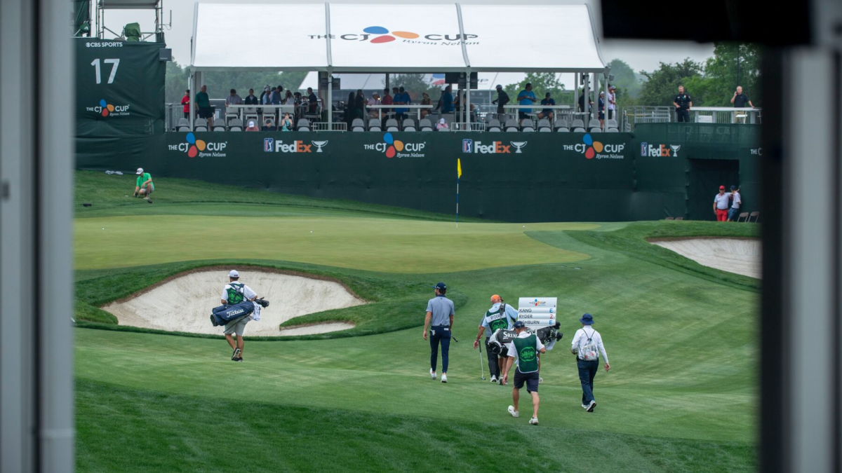 a group of golfers walking along a bright green course