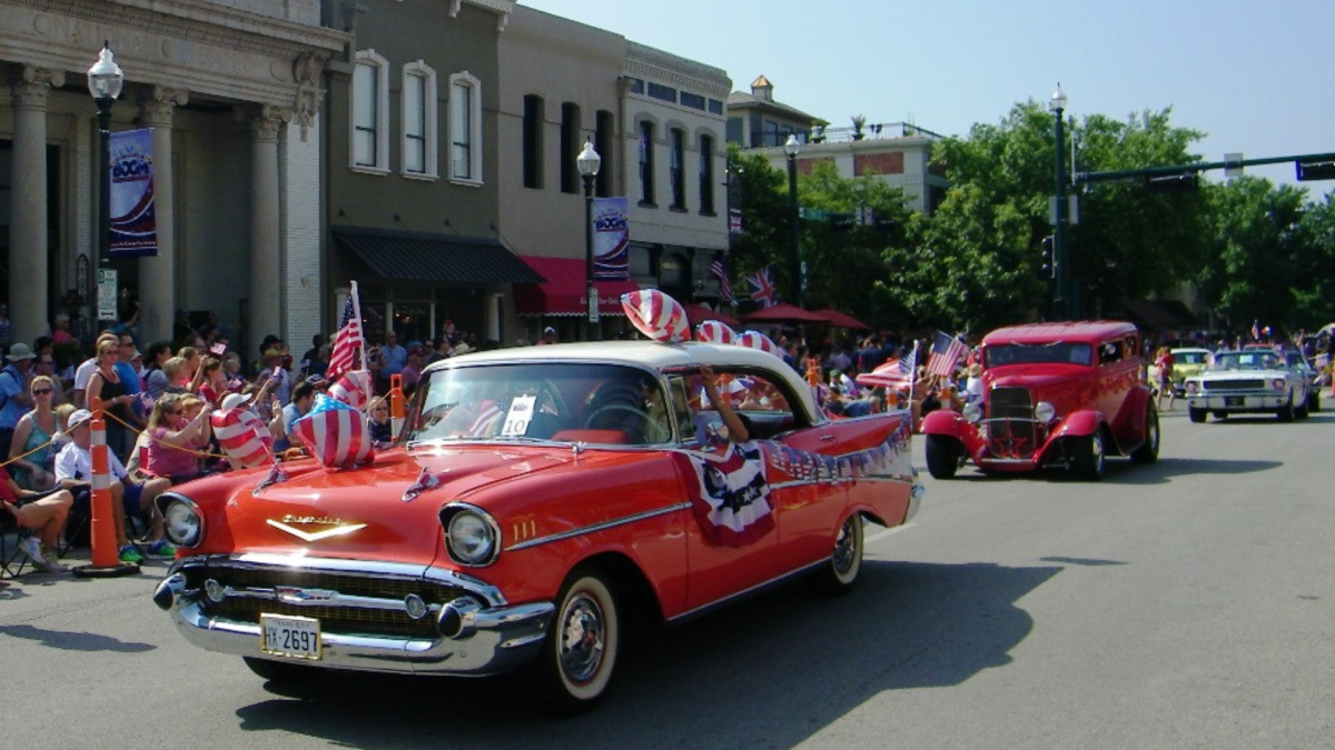 Parade of classic cars driving down the main street in McKinney