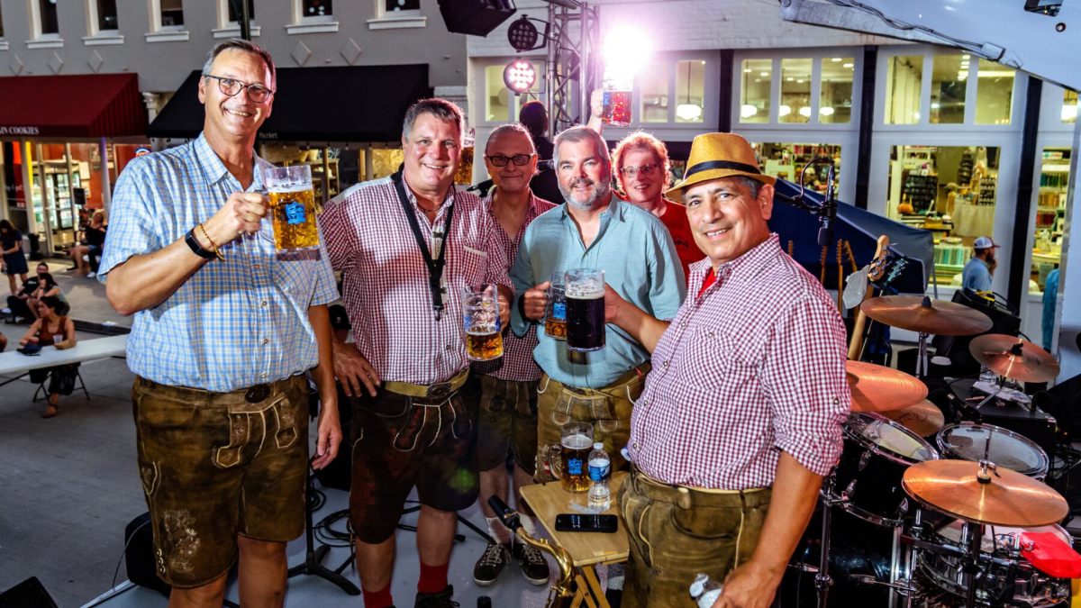 Group of people holding stein glasses full of beer