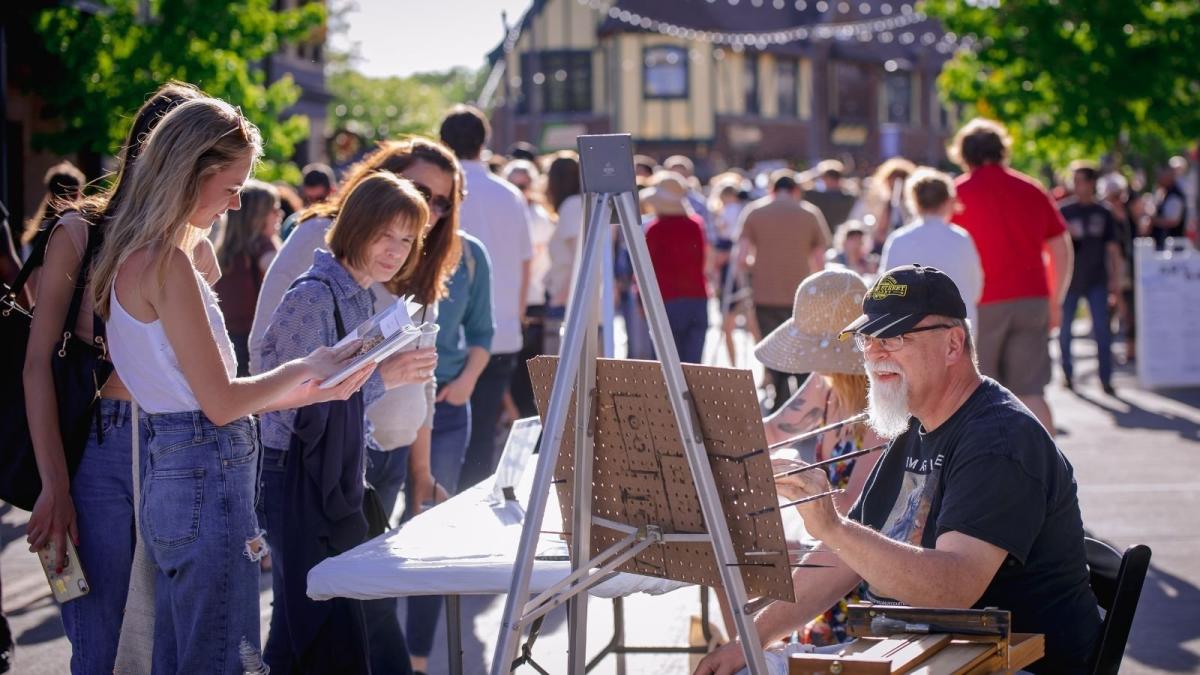 Man painting in front front of a group of people