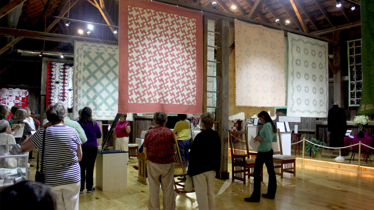 A group of museum patrons enjoying the quilts on display at the The Wisconsin Museum of Quilts & Fiber Arts
