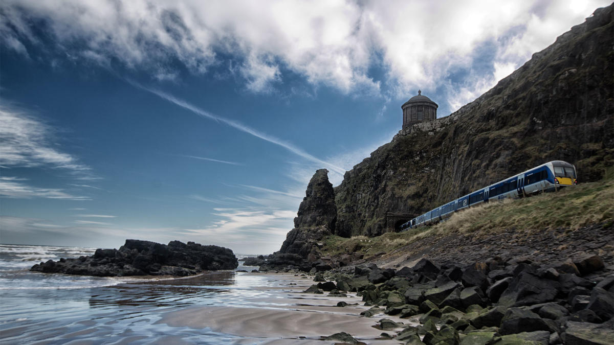 Train passes under Mussenden Temple along the water of Downhill Beach