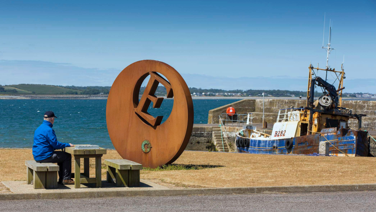 A man sits alone at a picnic bench at Burr Point
