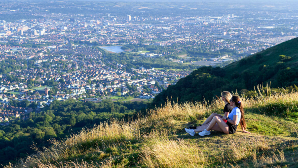 Two girls look out at the view of Belfast from Cave Hill