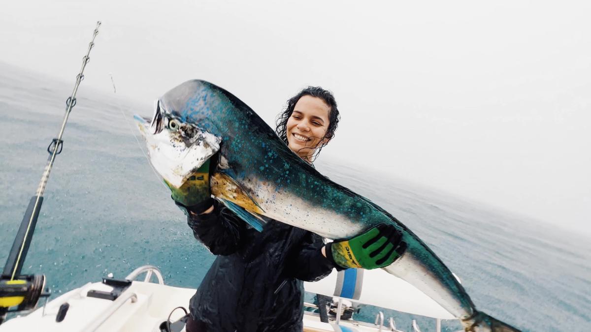 Woman smiling showing the catch of the day a beautiful fish