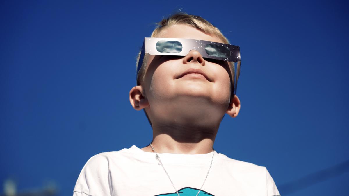 Boy wearing eclipse safety glasses