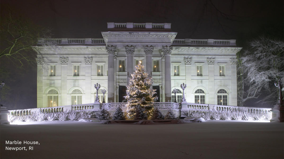 Night view of the exterior of Marble House, lit up with a Christmas Tree