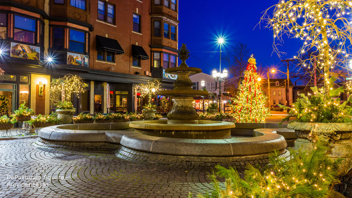 The square is decorated with holiday lights