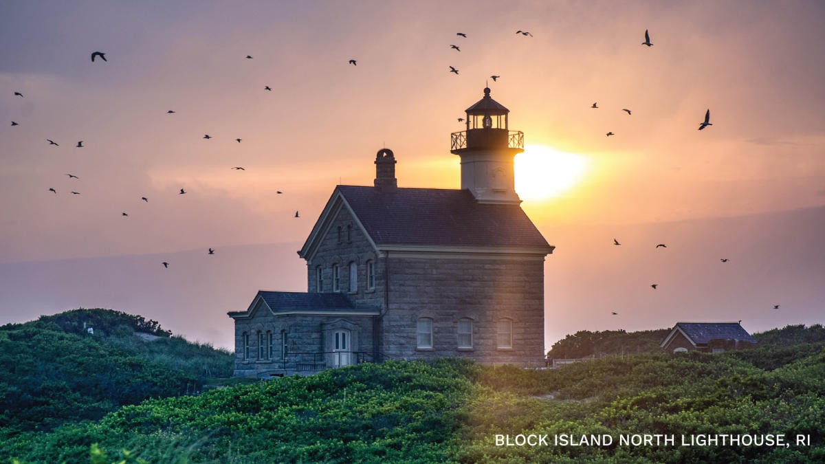 Birds circling the North Lighthouse at sunset.
