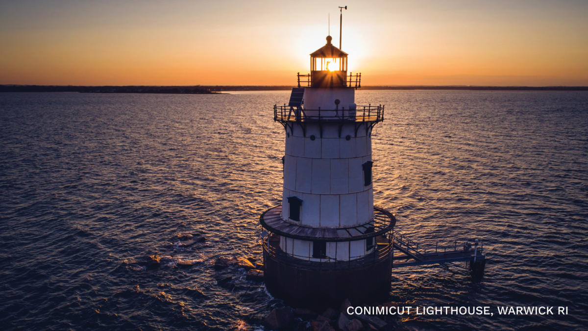 The Conimicut Lighthouse, surrounded by water, at sunset.