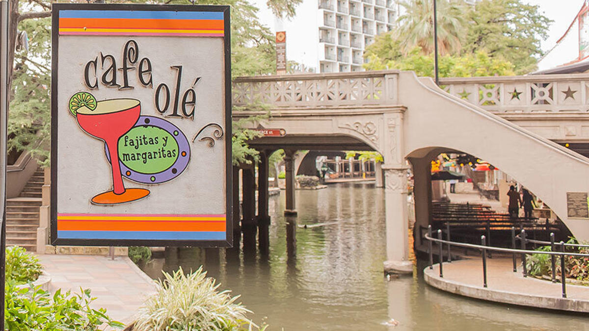 External view of Cafe Ole signage in front of bridge over River Walk