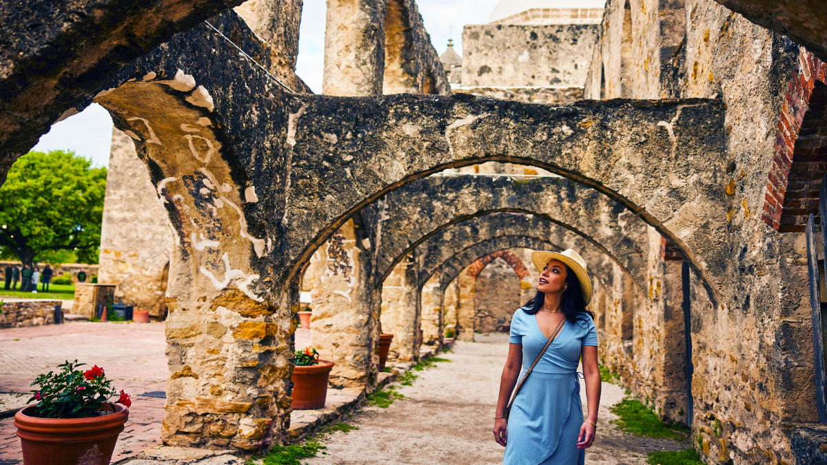 Woman walking under arches at missions