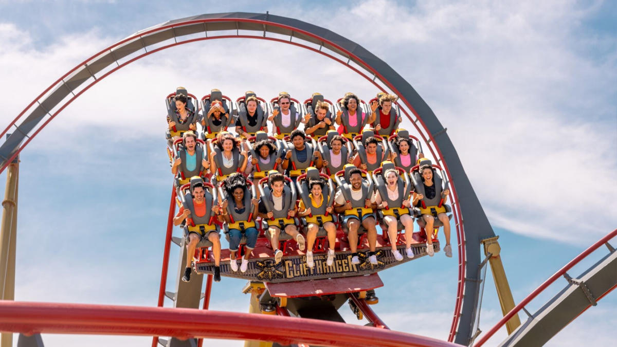 Roller coaster with three rows of people harnessed in