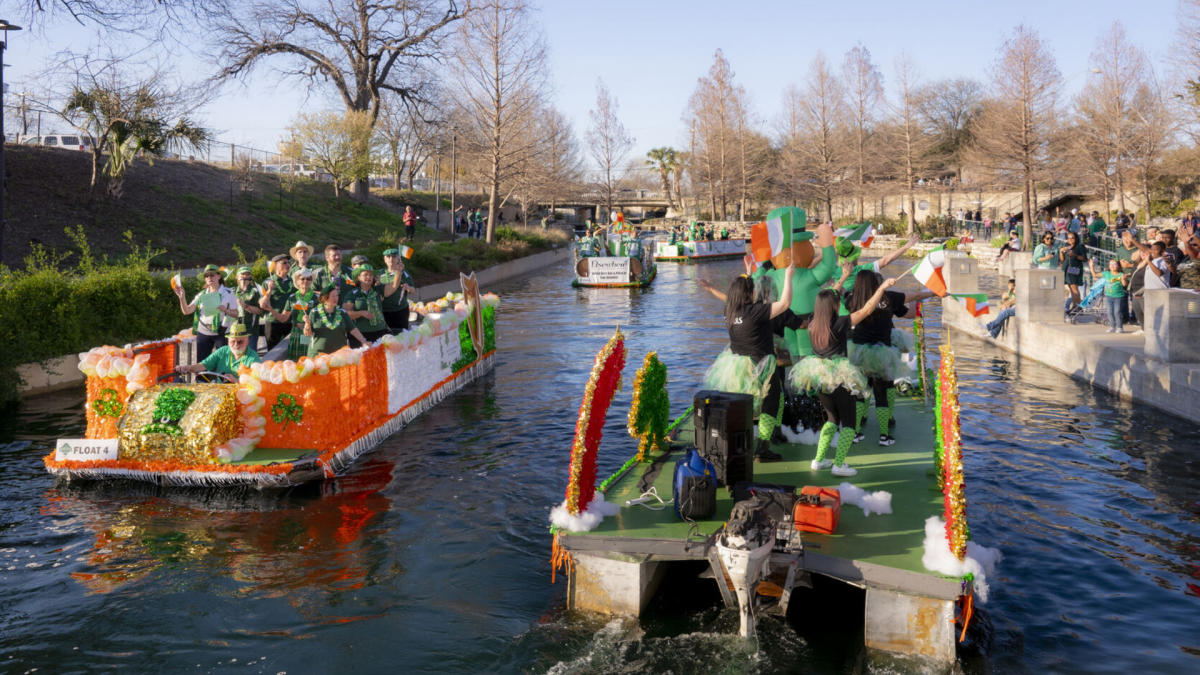 River barges decorated for St. Patrick's day floating past each other