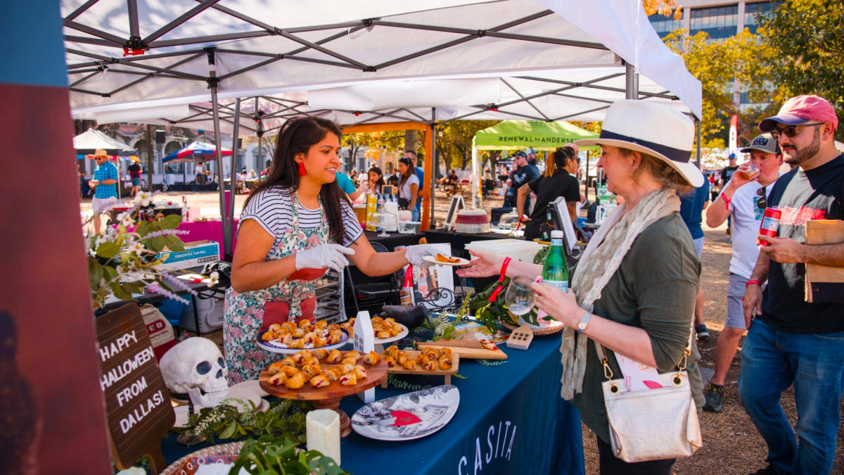 Woman handing plate of food to festival goer