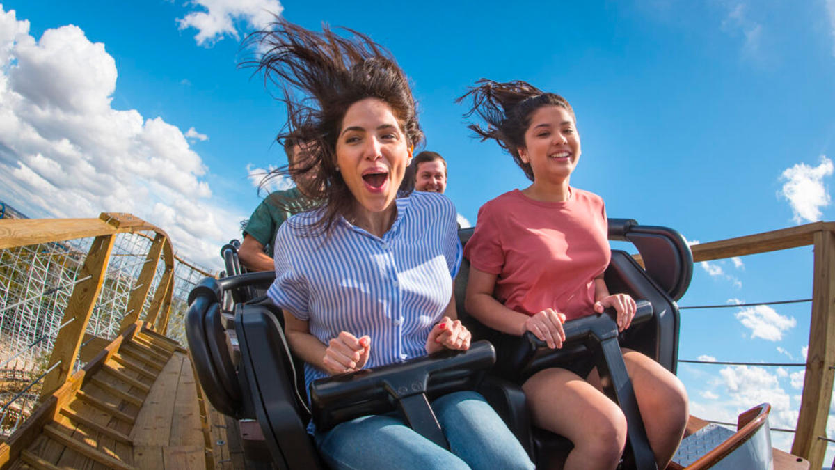 Friends on a rollercoaster going over a hill