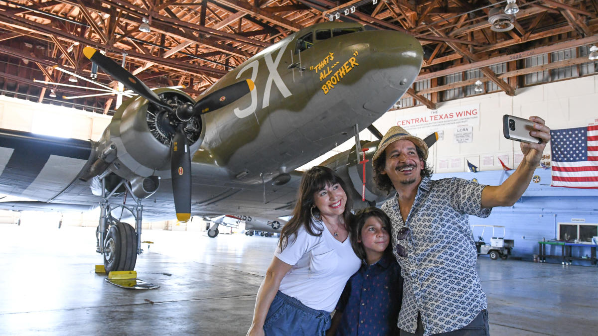 Family with little boy taking photo at WWII Bommer plane
