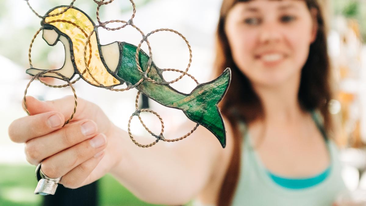 Woman touching stained glass mermaid