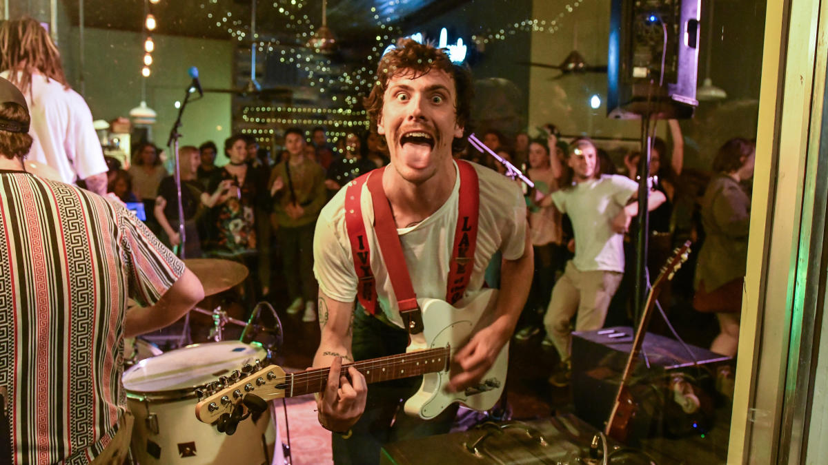 Guitar player in front of people dancing