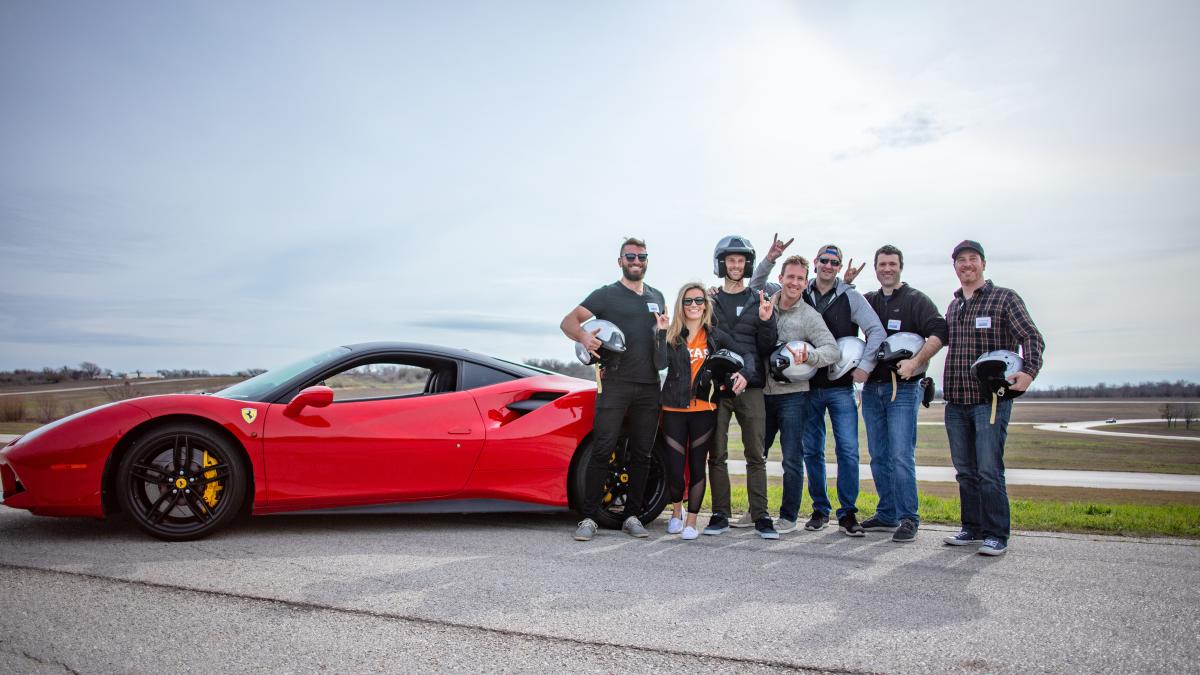 Group of people around race car on track