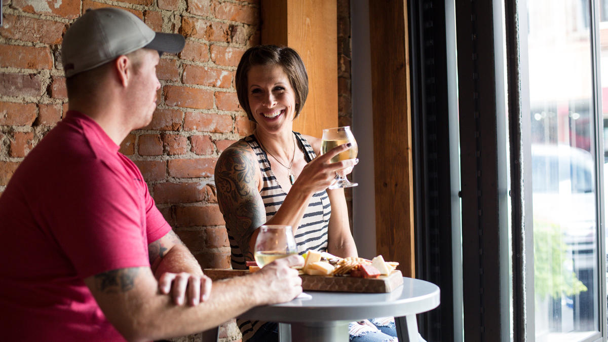 Couple eating and drinking at Aftermath Cidery