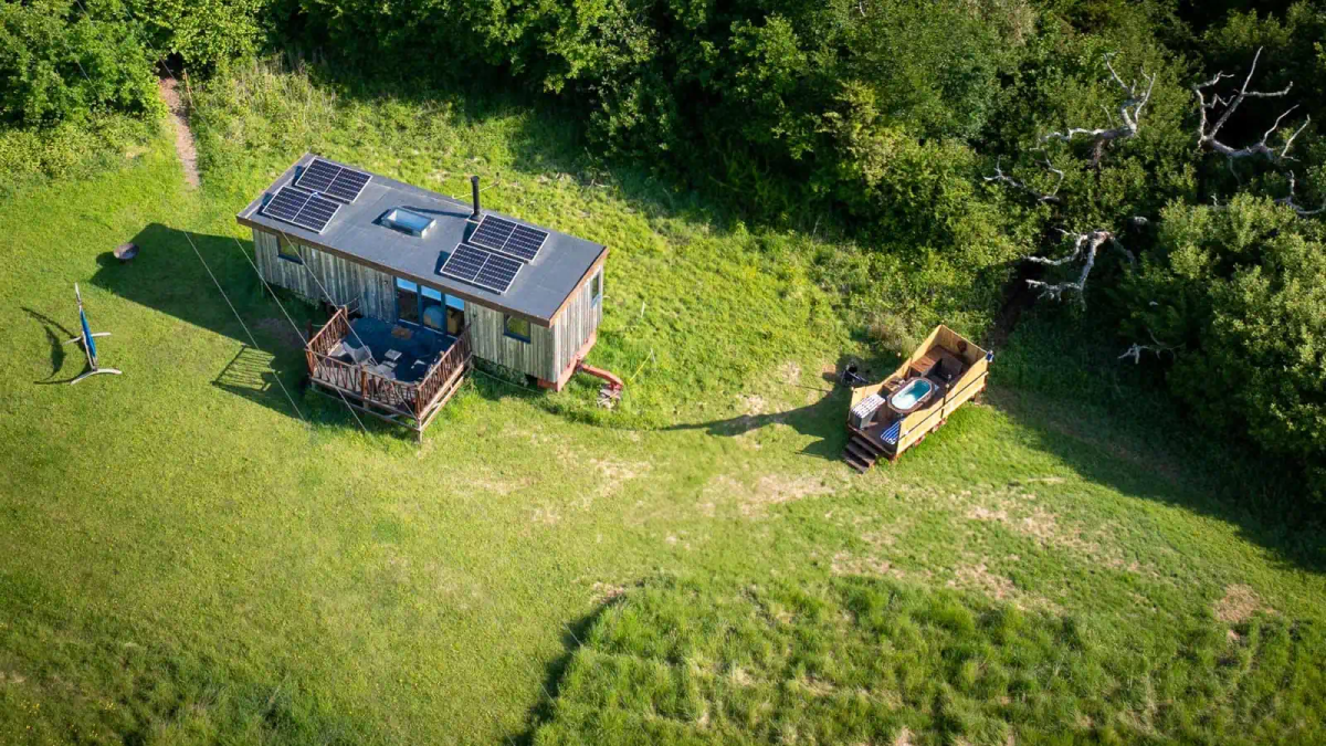 Aerial view of the Eco-Cabin and wood-fired hot tub set in a secluded meadow in the Sussex countryside