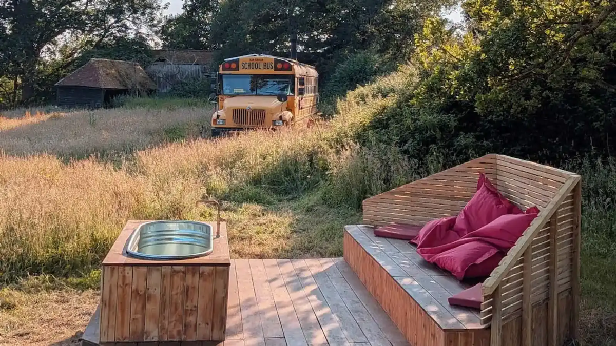 Converted American school bus glamping stay viewed from the hot tub deck in the Sussex countryside