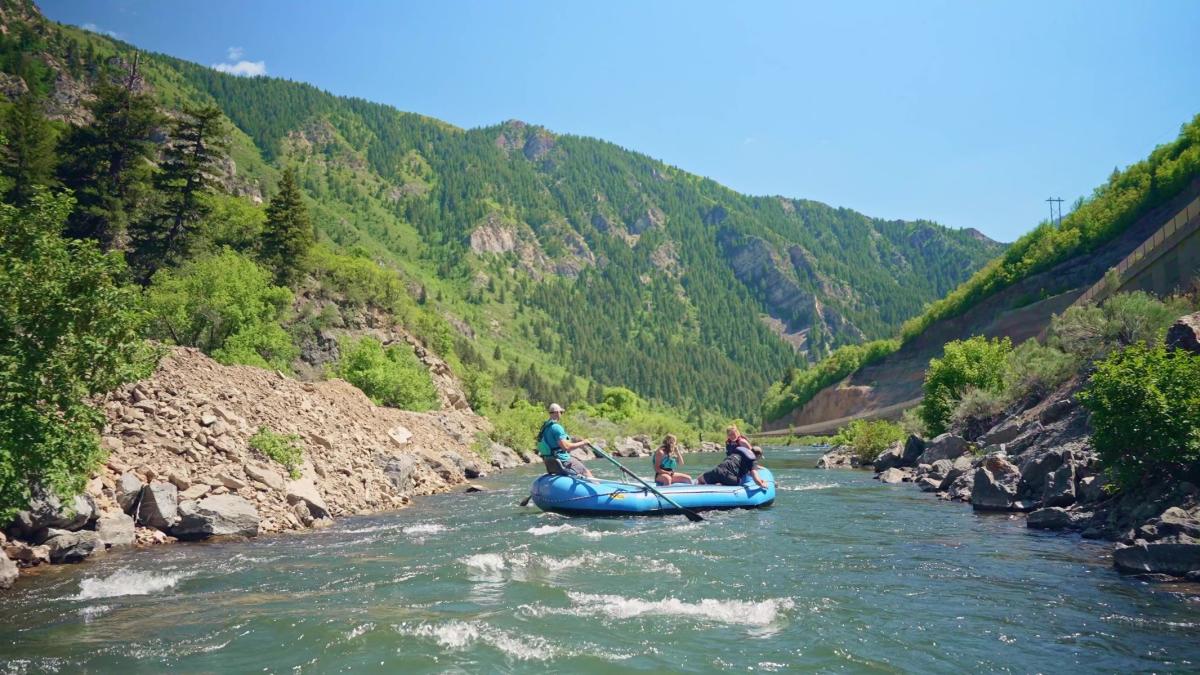 inflatable raft floating down scenic Provo River