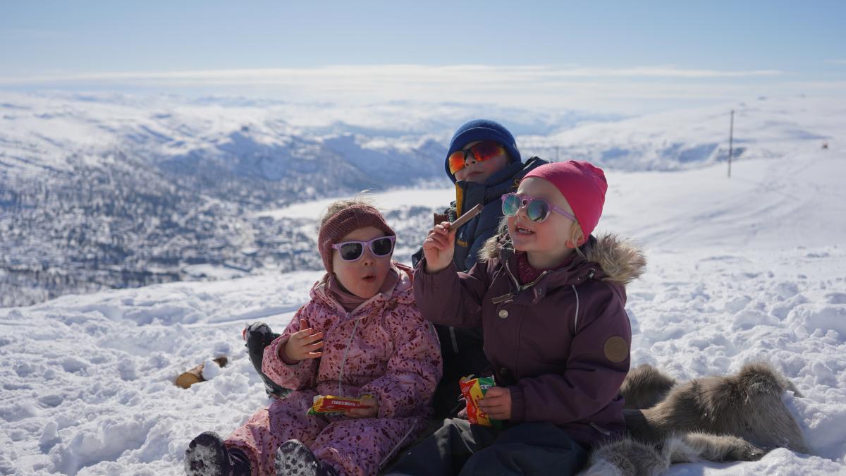 Barn som spiser Kvikk Lunsj på vinterfjellet i Setesdal