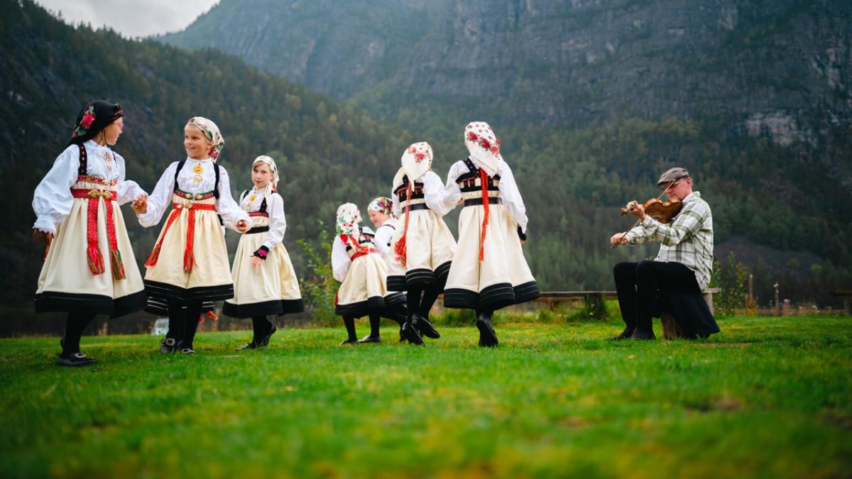 Jenter i bunad som danser gangar