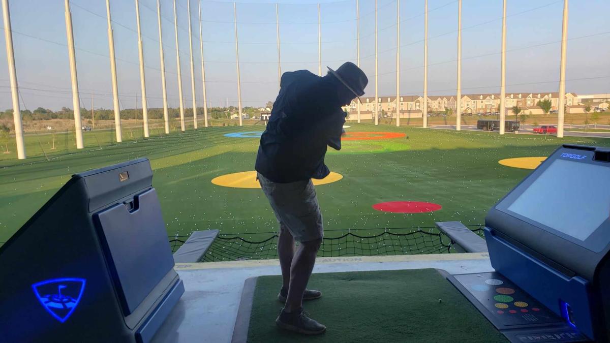 A man swings at a golf ball during a game at Topgolf