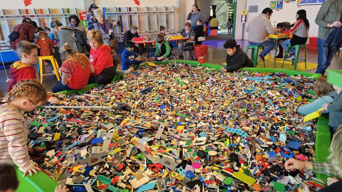 Kids dig through a pit of nearly one million Lego bricks at Exploration Place