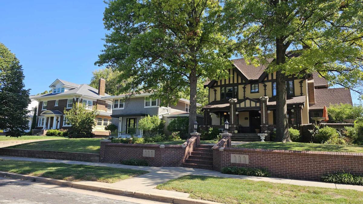 Two-story brick homes are photographed on a sunny day in College Hill