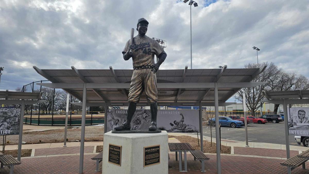 A bronze statue of jackie robinson greets visitors at McAdams Park