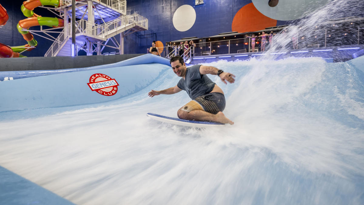 A man surfs on a surfing simulator at Blast Off Bay Water Park