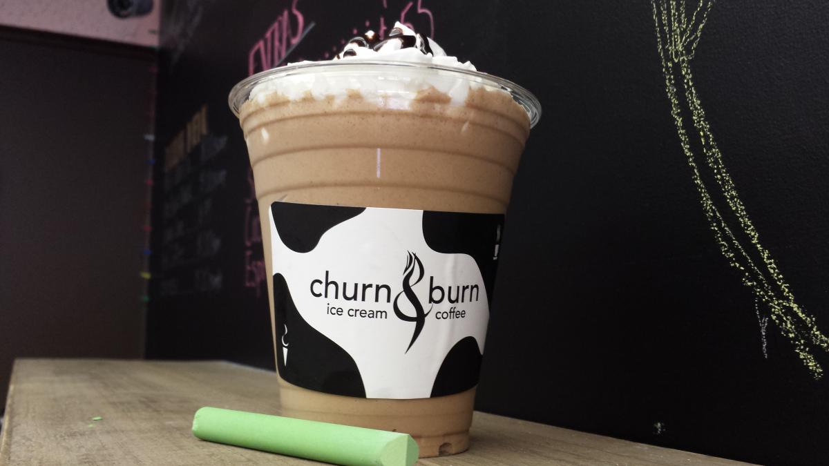 A frozen coffee and ice cream drink with whipped cream and sprinkles on top and a Church & Burn label