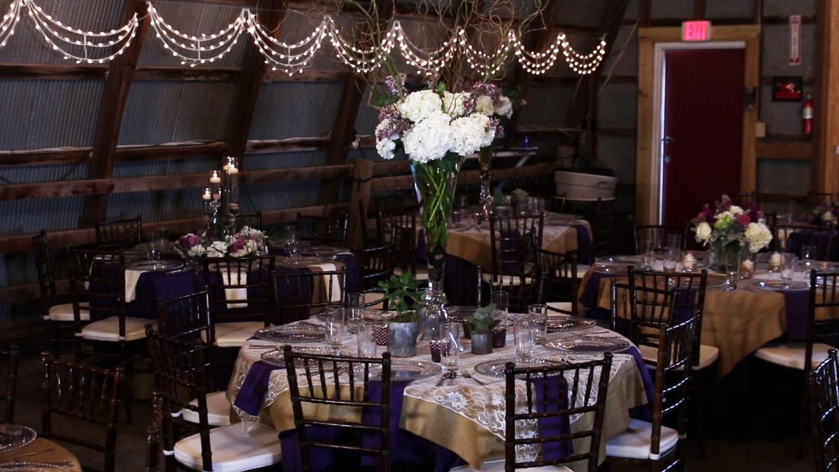 Tables are decorated for a wedding reception inside an event space at Fulton Valley Farms