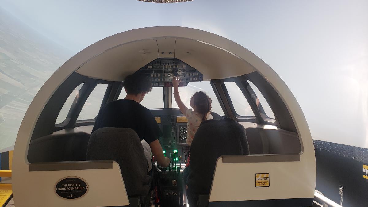 Two children play on a flight simulator at Wichita's Exploration Place