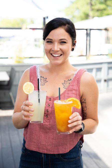 A girl holding two  drinks