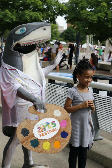 A child posing with Art Shark at Columbus Arts Festival