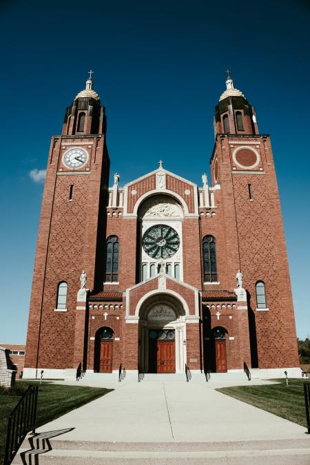 Large brick church in Pulaski, Wisconsin with twin 135-foot towers and stained glass windows.