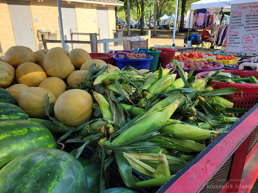 a red wagon full of fresh summer produce for sale at the Sunset Beach outdoor market