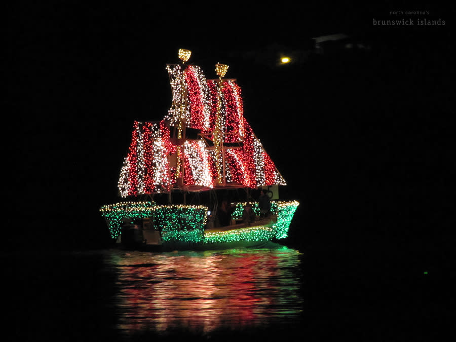 a boat decorated in Christmas lights to look like pirate ship