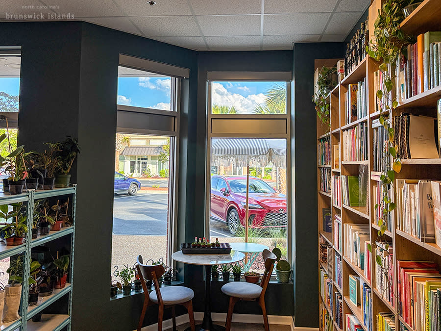 a small cafe table surrounded by shelves of plants and books at Palouse Coffee in Leland