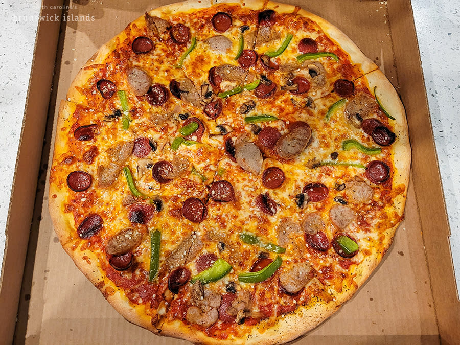 a large pizza topped with sausage, pepperoni, peppers, and mushrooms